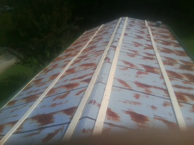 Rusted metal roof panels with new wood purlins before replacement — Storm Damage Roof Repair in Baileyton by Roofing Brothers