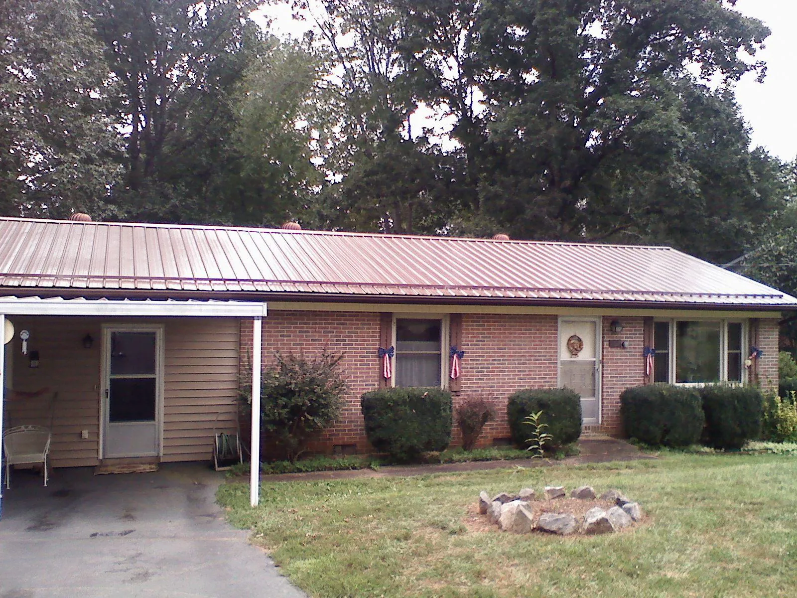 Bronze metal roof and carport on a brick ranch home — Roof Repair work by our crew in Baileyton